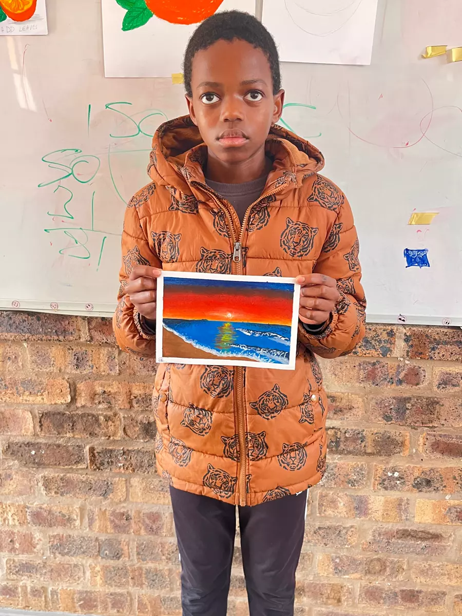 A boy holding up a painting he made