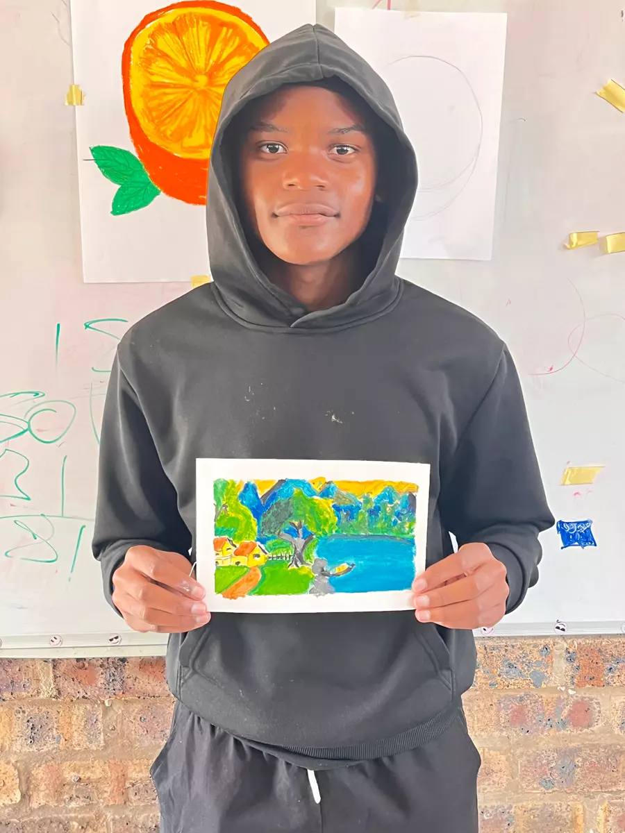 A young man holding a painting he created
