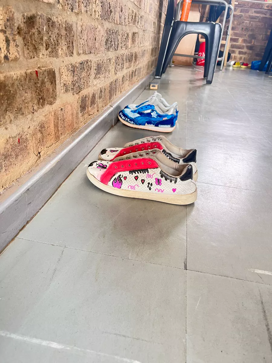 Customized sneakers lined up against a brick wall
