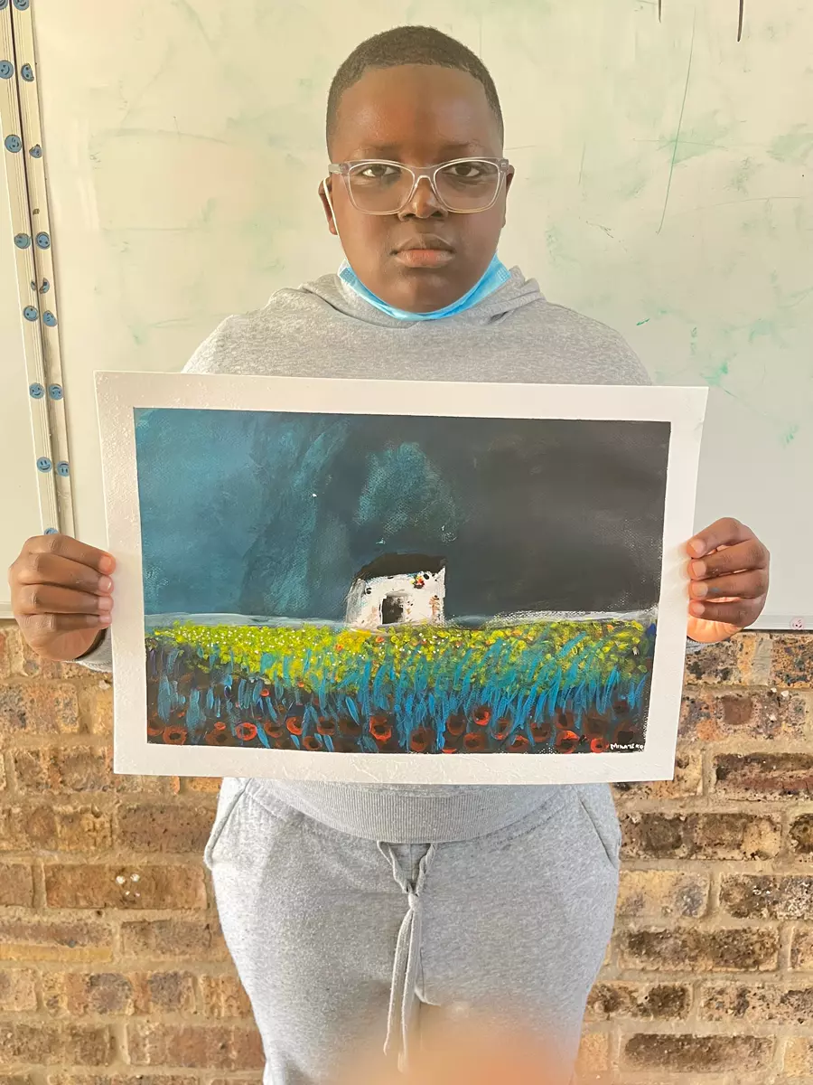 A young person holding up a painting they made